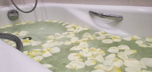 istock bath filled with water and white rose petals, relax 1280287217