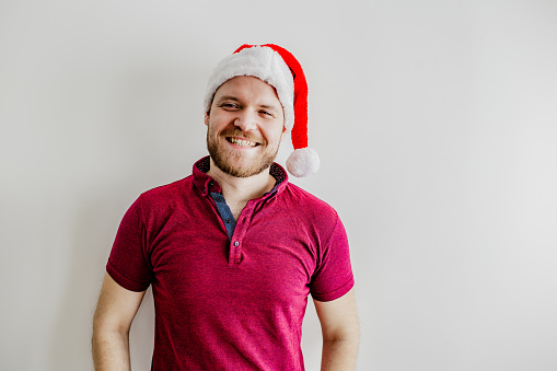 Young man with Santa hat looking at camera and smiling