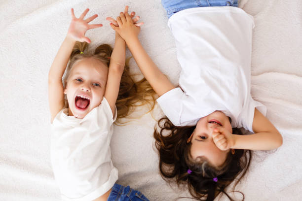 istock happy little girls lying on back top view sisters 1280290772