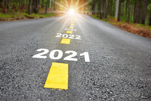 Viaje de año nuevo 2021 a 2024 sobre la superficie de la carretera de asfalto con líneas de marcado y luz solar photo