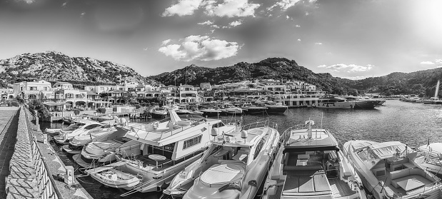 View of the harbor with luxury yachts of Poltu Quatu, Sardinia, Italy. This picturesque town is a real gem in Sardinia and a luxury yacht magnet and billionaires' playground