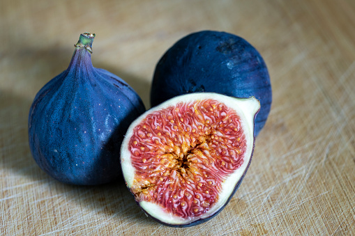 Ripe figs on a wooden surface close-up.