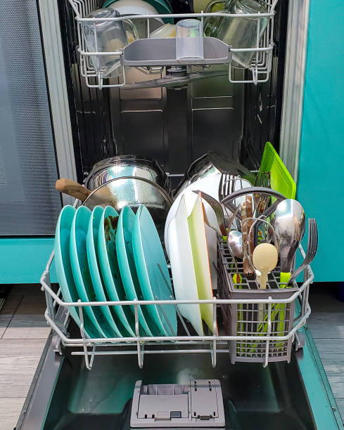 istock filled with different dishes, spoons, forks dishwasher. colorful Dishware inside built-in dishwasher 1280299088