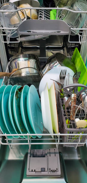 istock filled with different dishes, spoons, forks dishwasher. colorful Dishware inside built-in dishwasher 1280299109