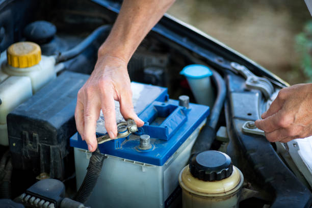 man connecting the car battery to the vehicle - car battery imagens e fotografias de stock