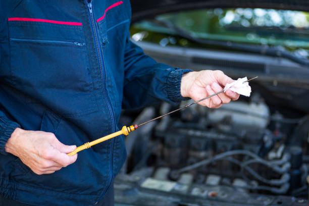 istock Man checking the car engine oil level in a workshop 1280299362