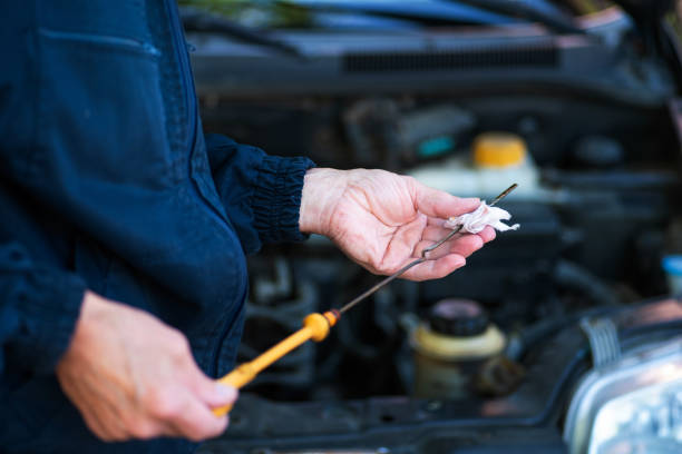 istock Man checking the car engine oil level in a workshop 1280299376