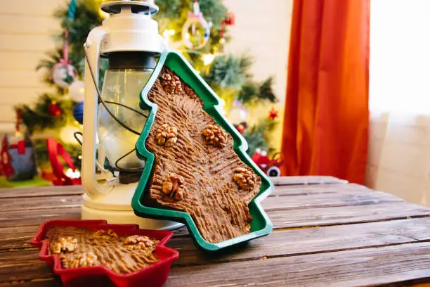 Homemade Christmas cake in the shape of a Christmas tree on a wooden table.