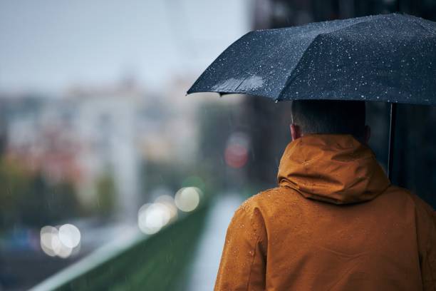 istock Man with umbrella during rain in city 1280302213