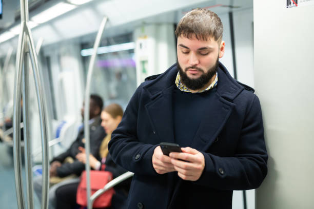 istock Young man with phone in metro car 1280304628