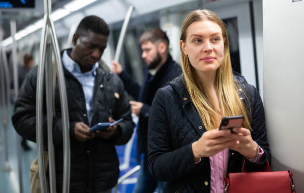 istock Young woman with phone in subway car 1280304636