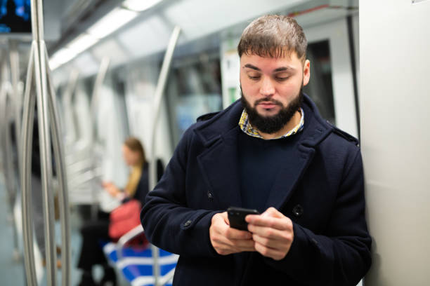 istock Young man with phone in metro car 1280304642