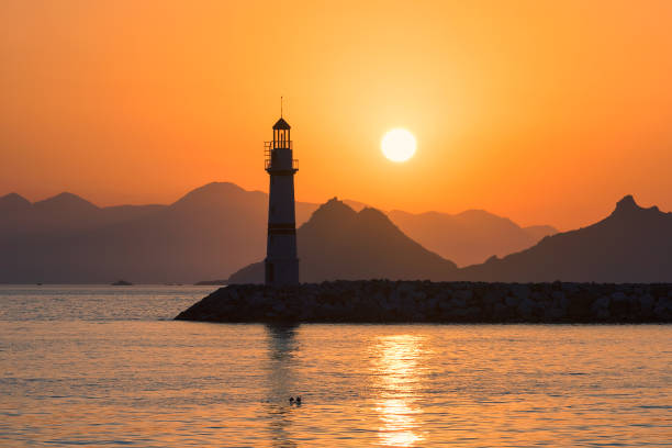 Sunset at Lighthouse in marina with yachts in Turgutreis, Bodrum, Turkey.