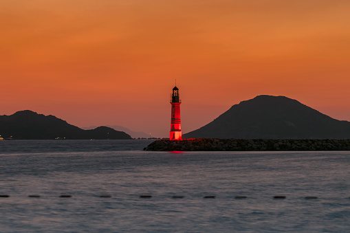 Sunset at Lighthouse in marina with yachts in Turgutreis, Bodrum, Turkey.