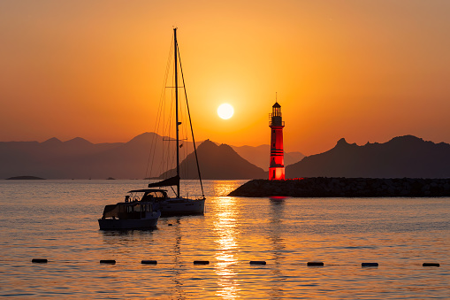 Sunset at Lighthouse in marina with yachts in Turgutreis, Bodrum, Turkey.