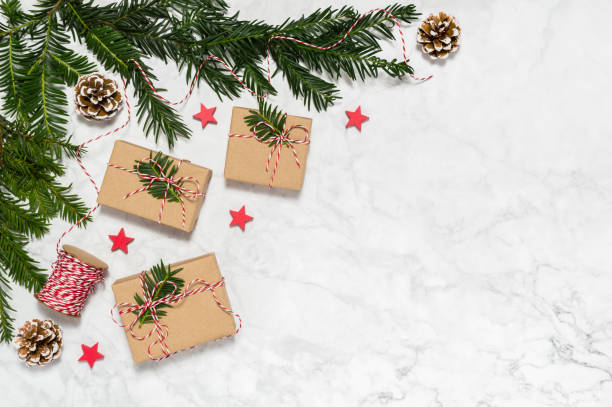 istock Plastic free Christmas flat lay with handmade giftboxes, conifer tree branches, pine cones, wooden stars on marble background. Copy space for text. Merry Christmas and Happy New Year holiday theme 1280305832