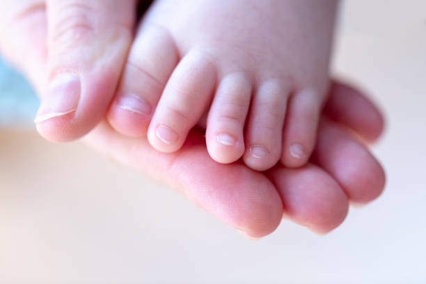mother hands holding small foots