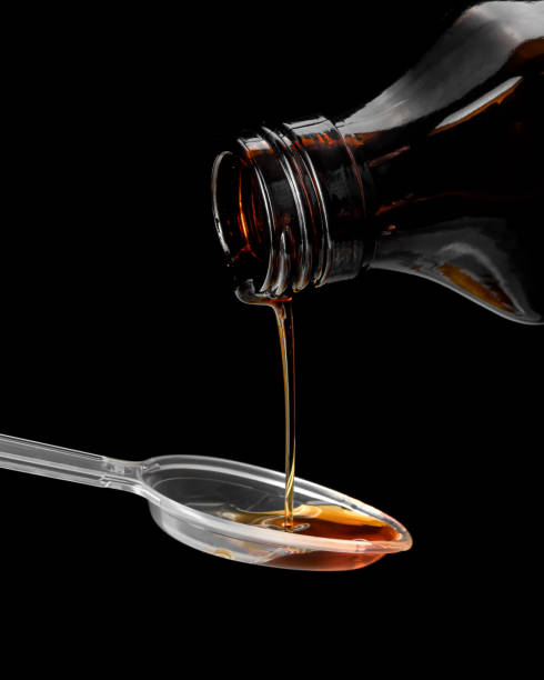 istock Syrup is poured into a spoon, on a black background 1280307682