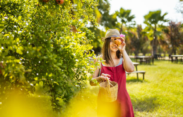 Young women having fun in the meadow while picking delicious cherries