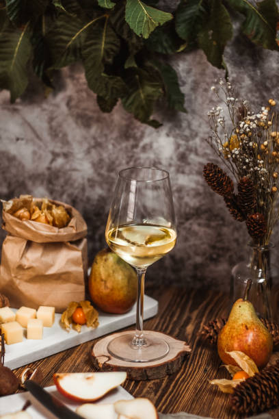 White Wine in autumn food scene with cheese and pears White Wine in autumn food scene with cheese and pears scene scented stock pictures, royalty-free photos & images