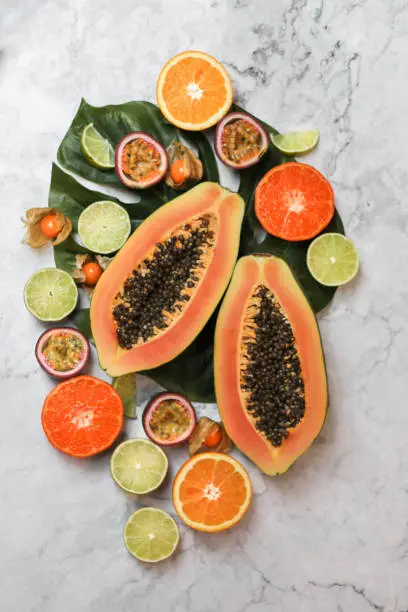 Tropical Fruits with Papaya and Passionfruit flat lay on white marble