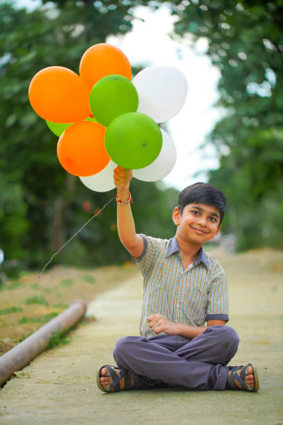 lindo niño indio con globos tri color y celebrando el día de la independencia o la república de la india - child patriotism saluting flag fotografías e imágenes de stock