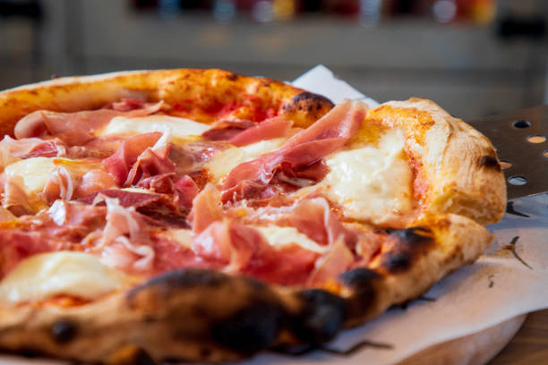 istock Taking a slice of whole baked pizza with ham and mozzarella, using spatula 1280309604