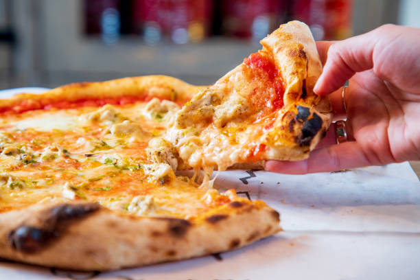 istock Taking a slice of whole pizza with tomato sauce base and melting cheese 1280309646