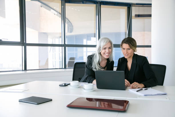 istock Cheerful business ladies looking at laptop display 1280310517
