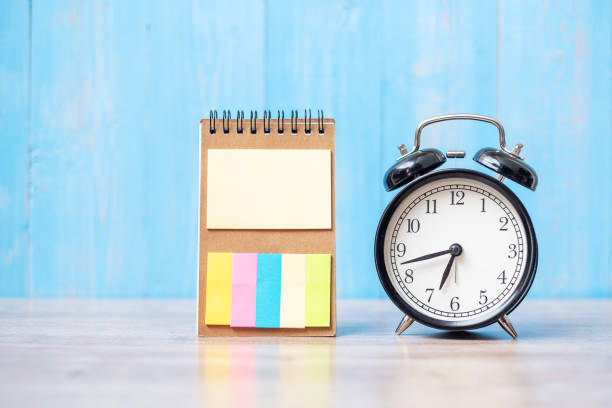 istock alarm clock with note paper on wooden table background and copy space for text. Activity, morning coffee break, workout and Work life balance concept 1280313477