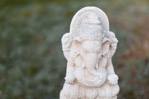 Front view of a Ganesha figure in a green garden [figure is Chinese mass product]