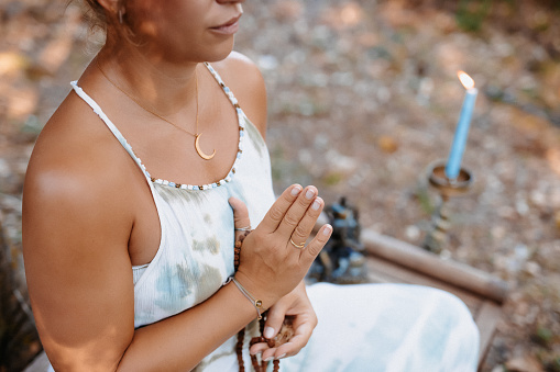 Meditating young woman sitting on a wooden bench, selective focus and  grain added, part of a series