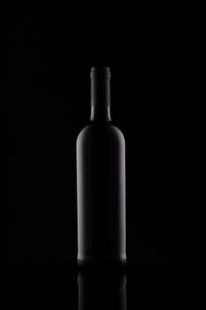 istock Wine bottle silhouette isolated on dark background. Mockup of bottle on dark backdrop. 1280314978