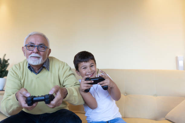 istock Handsome Grandpa and Grandson are Playing Game Console While Spending Time Together at Home. 1280315148