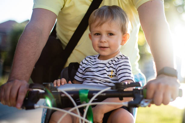 istock Father riding the bicycle with son in the seat 1280315165