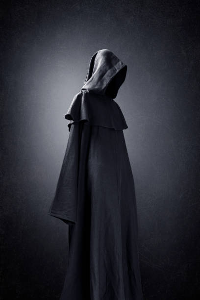 Scary figure in hooded cloak stock photo