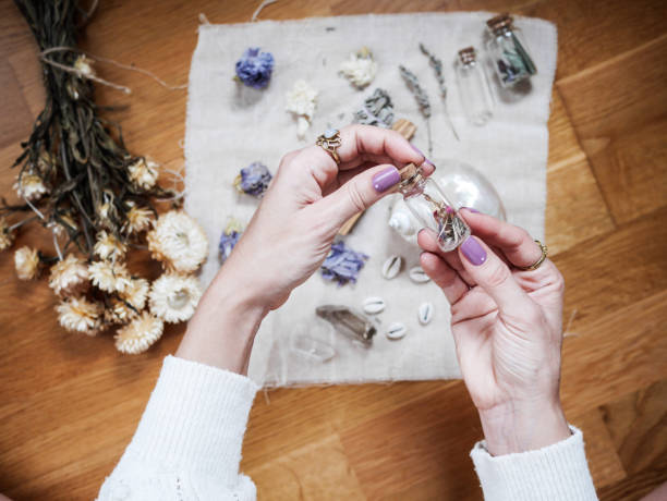 A girl is holding a little glass jar on her altar in lavender tones A girl is holding a little glass jar on her altar in lavender tones. You can see dried flowers and crystal jars. crystal altar stock pictures, royalty-free photos & images
