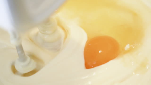 SLOW MO Mixing butter and eggs by electric mixer.