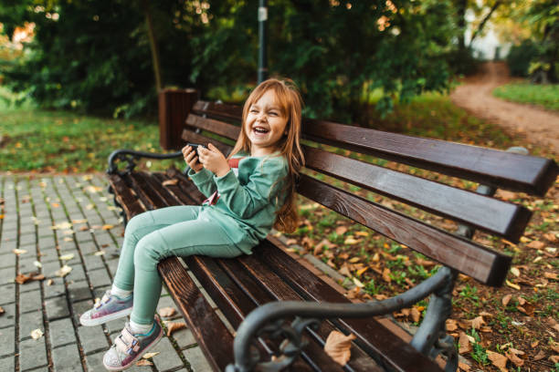 istock Smiling little girl using smart phone 1280317918