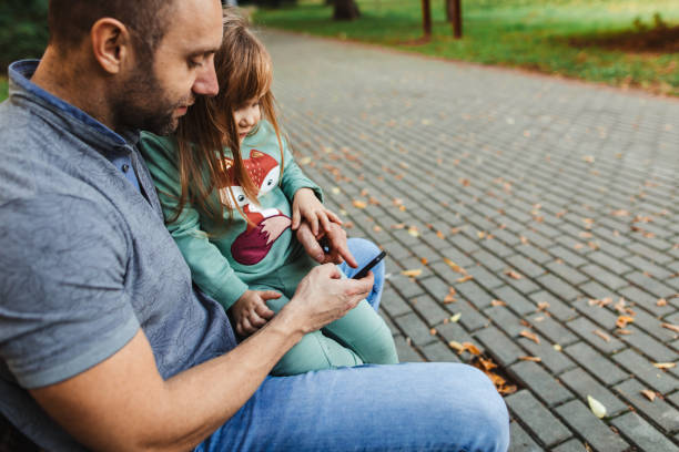 istock Father and daughter have fun with technology in public park 1280318111