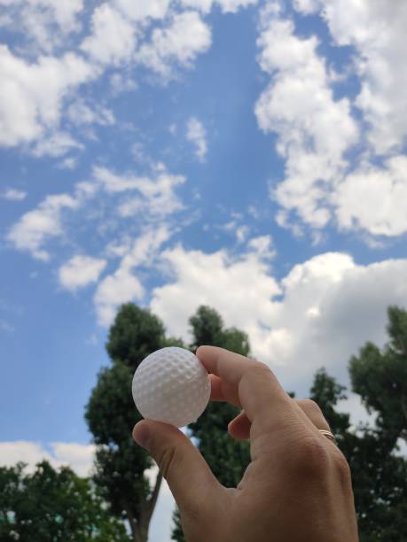 golf ball in a man's hand in nature