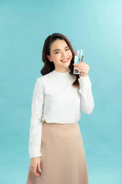 Photo of young woman drinks clean water adheres to drinking regime.