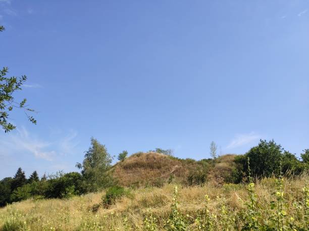 istock green grassy hill against blue sky in summer 1280319098