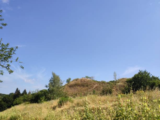 istock green grassy hill against blue sky in summer 1280319694