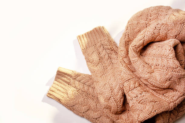 istock Warm knitted beige sweater on a white table. View from above. Autumn concept 1280320307