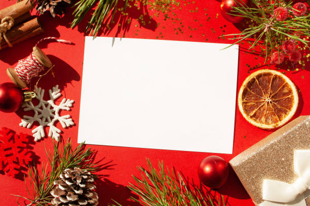 istock Christmas frame, Christmas tree branches and New Year's decor. Blank writing sheet on a red background. View from above 1280320779