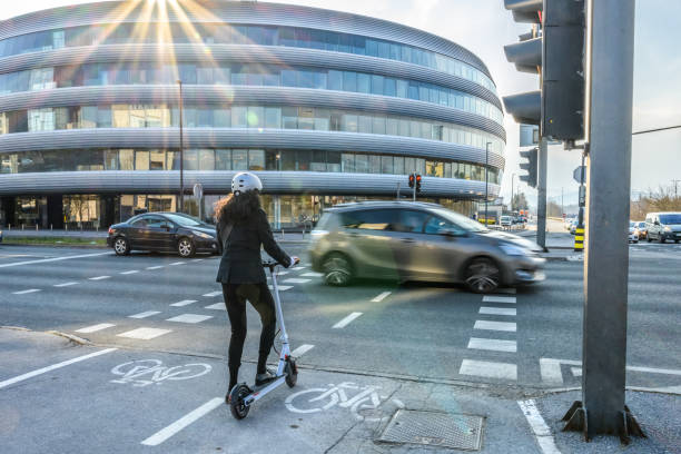istock Businesswoman waiting for traffic light with her e-scooter 1280322193