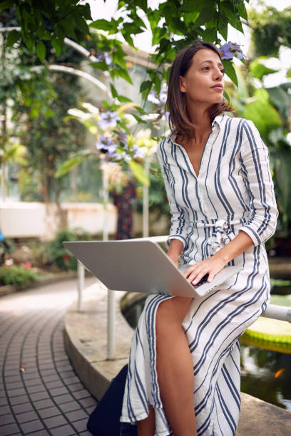 Young female student taking notes in a botanical garden
