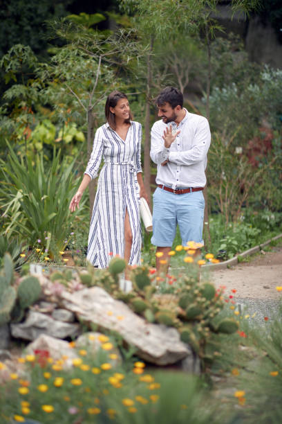 istock Young female guide and a young male visitor in a conversation about plants 1280322540