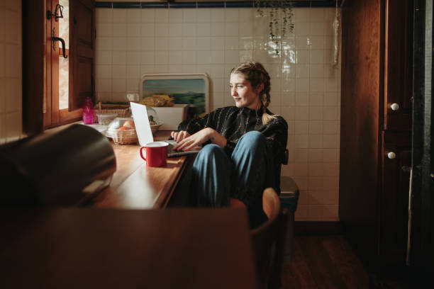 istock Young woman using her laptop in a kitchen 1280324034